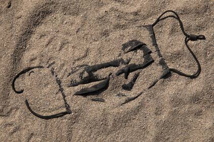 Una máscara protectora contra el coronavirus desechada en la arena de Miami Beach, Florida, el 7 de marzo de 2021