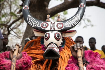 Una máscara tradicional que representa un búfalo durante la espera para el comienzo del desfile