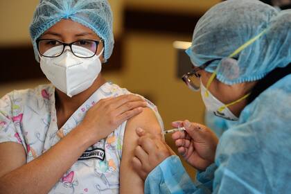 Una médica recibe una dosis de la vacuna rusa Sputnik V contra la enfermedad del nuevo coronavirus, en el Hospital Cotahuma de La Paz, Bolivia, el 3 de febrero de 2021
