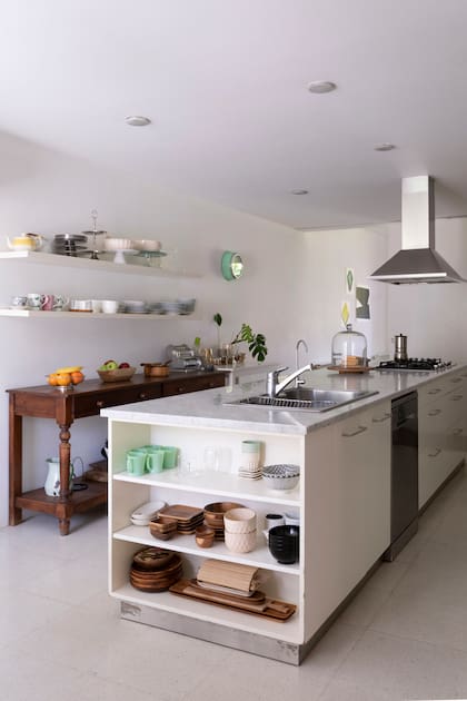 Una mesa auxiliar rústica aporta la cuota cálida a la paleta de colores de la cocina.