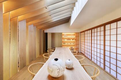 Una mesa de roble francés con borde natural rodeada de sillas Hans Wegner Wishbone, también en roble, adorna el comedor “europeo”; las mamparas corredizas shoji ocultan una cocina.