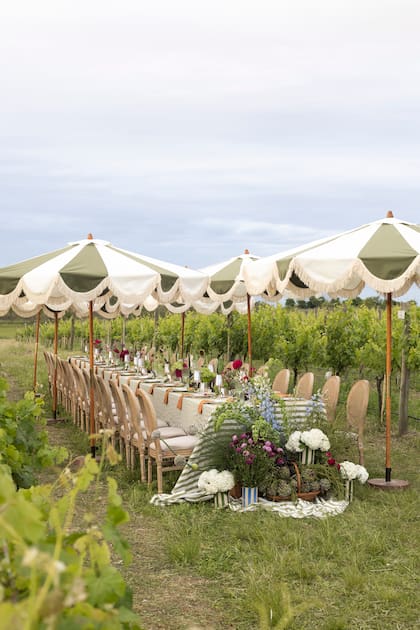 Una mesa que se funde con el paisaje del viñedo: textiles en tonos verdes y detalles naturales que dialogan con el entorno para crear una experiencia única al aire libre.