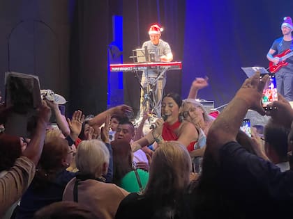 Una mujer abraza a Leda mientras le canta al público