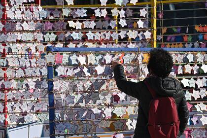 Una mujer adjunta una tarjeta en la que desea el éxito de los estudiantes que realizan el examen anual de capacidad académica universitaria en el templo Jogye en Seúl el 3 de diciembre de 2020