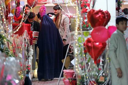 Una mujer afgana vestida con burka compra regalos en una tienda con motivo del Día de San Valentín en Jalalabad
