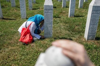 Una mujer bosnia junto a la tumba de un familiar en el cementerio donde reposan las víctimas de la masacre de Srebrenica