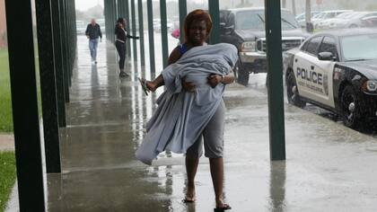 Una mujer busca refugio ante la llegada de las primeras lluvias por el huracán