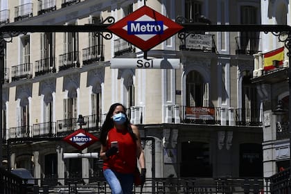 Una mujer camina con barbijo por la Puerta del Sol, una plaza de la ciudad española de Madrid, en medio de la pandemia de coronavirus