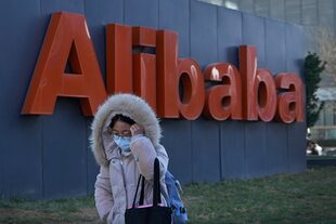 Una mujer camina delante de las oficinas del gigante de comercio en la internet Alibaba en Pekín el 13 de diciembre del 2021. 