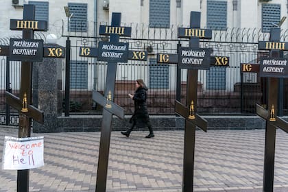 Una mujer camina frente al Parlamento de Kiev, con carteles de denuncian la "ocupación de Rusia". (Brendan Hoffman/The New York Times)