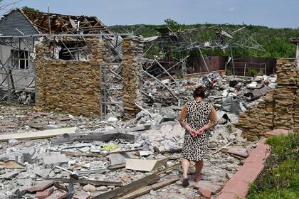 Una mujer camina junto a una vivienda destruida durante un ataque con misiles, el miércoles 1 de junio de 2022, en Sloviansk, Ucrania. (AP Foto/Andriy Andriyenko)