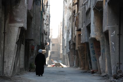 Una mujer camina por el campamento de Yarmouk en Damasco, Siria, que ha sido testigo de intensos combates durante la guerra civil, el miércoles 2 de noviembre de 2022.
