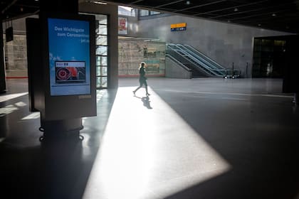 Una mujer camina por la estación de Potsdamer Platz en Berlín, vacía por miedo al coronavirus