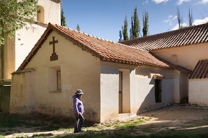 Una mujer camina por la parte de atrás de la iglesia de Yavi