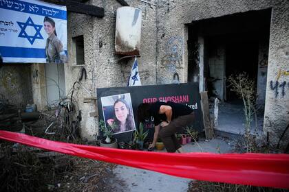 Una mujer coloca una vela en un punto de homenaje a Ofir Shoshani durante un acto de recuerdo a los dos años de un ataque transfronterizo a Israel, en el kibbutz Kfar Aza, el martes 7 de octubre de 2025. (AP Foto/Ohad Zwigenberg)