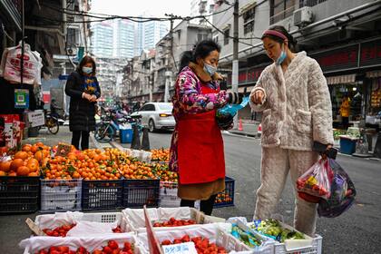 Una mujer compra fruta en un mercado local en Wuhan, en la provincia central china de Hubei, el 23 de enero de 2023. 