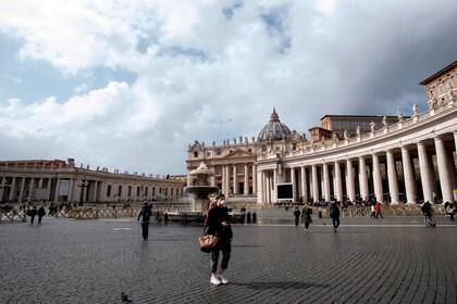 Una mujer con barbijo camina en la plaza de San Pedro en el Vaticano