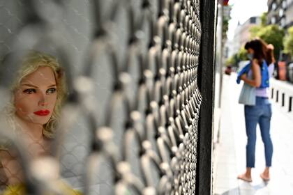 Una mujer con tapabocas pasa junto a una tienda cerrada en el centro de Madrid el 16 de septiembre de 2020