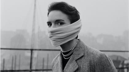 Una mujer con tapabocas y perlas en los 1950.
