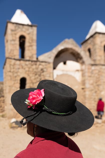 Una mujer con un sombrero típico en Pueblo Viejo, detrás se puede ver la iglesia del pueblo