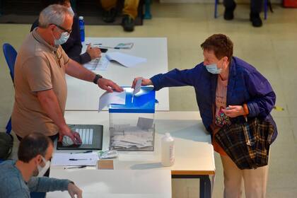 Una mujer con una máscara facial emite su voto en un colegio electoral en San Sebastián, durante las elecciones regionales vascas, el 12 de julio de 2020