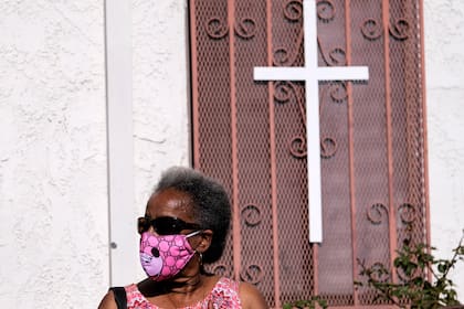 Una mujer con una mascarilla espera en la fila en la Iglesia de Cristo de Southside en Los Ángeles, California, el 18 de enero de 2021 mientras se administran pruebas de PCR y de anticuerpos a los residentes locales en honor al Día de Martin Luther King Jr