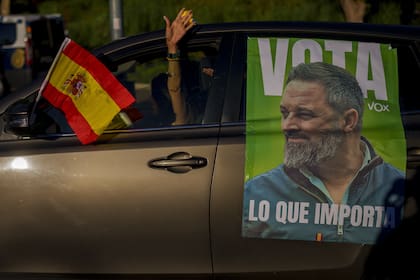 Una mujer conduce su coche con una imagen del líder del partido de extrema derecha Vox, Santiago Abascal, antes de un evento de campaña electoral en Guadalajara, España, el sábado 15 de julio de 2023. 