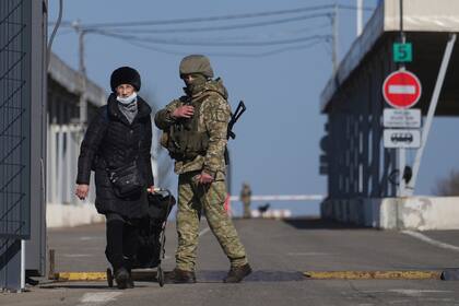 Una mujer cruza el punto de control en Novotroitske, en el este de Ucrania (AP Photo/Evgeniy Maloletka)