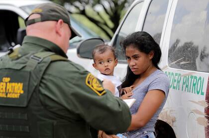 Una mujer de Honduras sostiene a su hijo de 1 año mientras se entrega a un agente de la Patrulla Fronteriza tras cruzar ilegalmente la frontera de Estados Unidos con México, el lunes 25 de junio de 2018, cerca de McAllen, Texas (AP Foto/David J. Phillip, archivo)