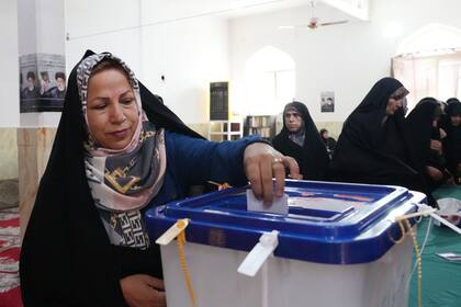 Una mujer emite su voto en Teherán (Photo by RAHEB HOMAVANDI / AFP)