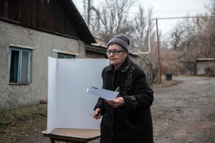 Una mujer emite su voto en un colegio electoral móvil durante la votación anticipada de las elecciones presidenciales de Rusia en Donetsk, Ucrania controlada por Rusia, en medio del conflicto Rusia-Ucrania el 14 de marzo de 2024. (STRINGER / AFP)