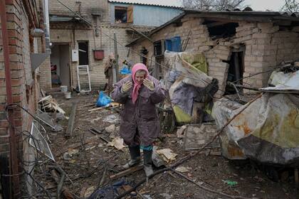 Una mujer en patio de una casa dañada por un bombardeo ruso el 2 de marzo de 2022.