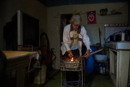 Una mujer enciende carbón para cocinar la cena durante un apagón programado con el fin de racionar la energía en Santa Cruz del Norte, sede de una de las centrales termoeléctricas más grandes de Cuba