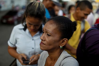 Una mujer espera resignada viajar en un camión de carga