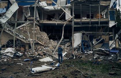 Una mujer frente a los edificios destruidos tras el bombardeo ruso en Mykolaiv, Ucrania, el miércoles 3 de agosto de 2022.