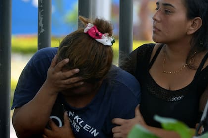 Una mujer gesticula mientras espera el cuerpo de una de las víctimas del tiroteo de la víspera en una cooperativa, frente al Laboratorio de Criminalística y Ciencias Forenses, en Guayaquil, Ecuador, el 31 de marzo de 2024. 