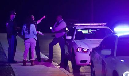 Una mujer habla con la policía cerca del centro de FedEx luego de un tiroteo en Indianápolis, IN., el viernes 16 de abril de 2021.