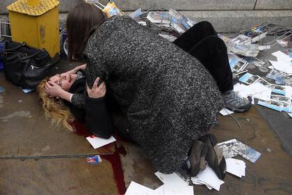 Una mujer herida tirada en la vereda luego del atentado de Khalid Masood, en Londres. Masood atropelló a peatones con su auto, logrando matar a cuatro y a un oficial de policía en el puente de Westminster. 22 de marzo de 2017