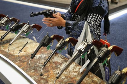 Una mujer inspecciona un revolver en un evento de la NRA llevado a cabo en 2018 en Dallas, Texas