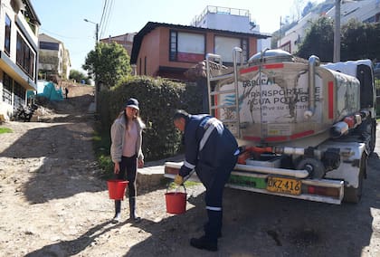 Una mujer junta agua potable de un camión cisterna en La Calera, cerca de Bogotá, el 10 de abril de 2024. 