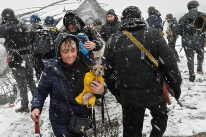 Una mujer lleva a su perro durante la evacuación de civiles de la ciudad de Irpin, al noroeste de Kiev