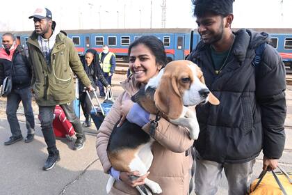 Una mujer lleva a su perro mientras llegan refugiados de Ucrania a la estación de tren en la ciudad fronteriza húngaro-ucraniana de Zahony, el 1º de marzo de 2022