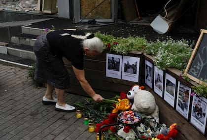 Una mujer local coloca flores en el altar improvisado ante la pizzería RIA, atacada por un cohete ruso en Kramatorsk, en la región de Donetsk, Ucrania, el jueves 29 de junio de 2023.  (AP Foto/Alex Babenko)