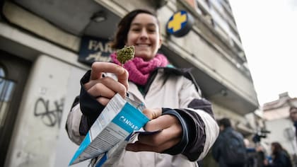 Una mujer muestra un paquete de marihuana comprado en una farmacia en Uruguay