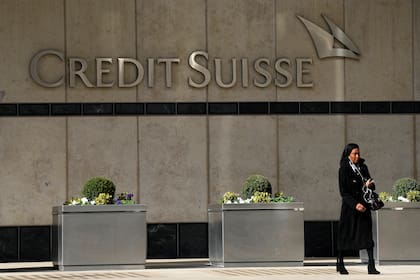 Una mujer pasa frente a la sede del banco Credit Suisse en Londres, jueves 16 de marzo de 2023. Las acciones de Credit Suisse aumentaron 30% el jueves con el anuncio de un préstamo de casi 54.000 millones de dólares del Banco Central suizo. (AP Foto/Frank Augstein)