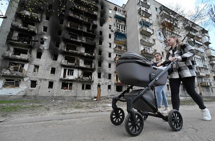 Una mujer pasa junto a un edificio severamente dañado en Chernihiv
