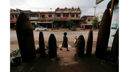 Una mujer pasa junto a un restaurante decorado con bombas sin explotar