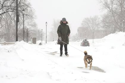 Una mujer pasea a su perro mientras cae nieve en Des Moines, Iowa.