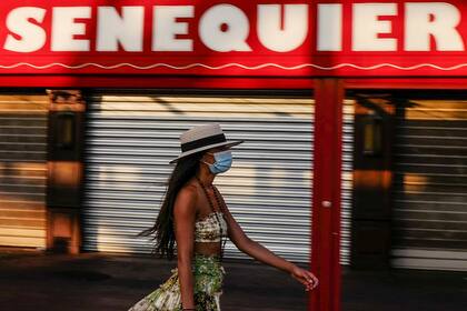 Una mujer pasea por el puerto de Saint-Tropez el 16 de agosto de 2020 con mascarilla, ya que la ciudad hizo obligatorio el uso de tapabocas en el centro de la ciudad debido a un resurgimiento del coronavirus
