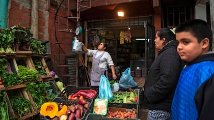 Una mujer pesa verduras en su tienda de la Villa 31 en Buenos Aires, Argentina